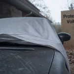 Proteger voiture dehors : bâche respirante sous abri léger, pluie et poussière visibles